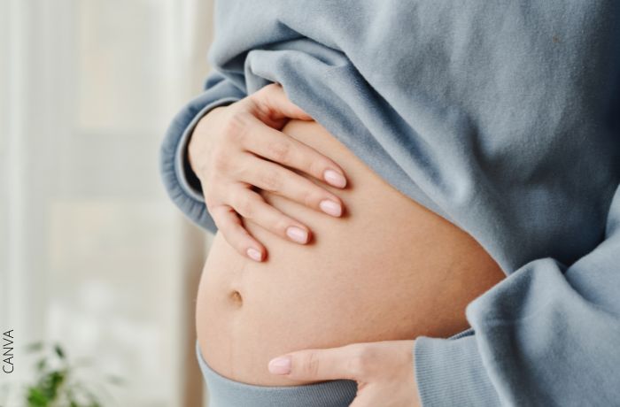 Foto de una mujer embarazada con las manos en el vientre