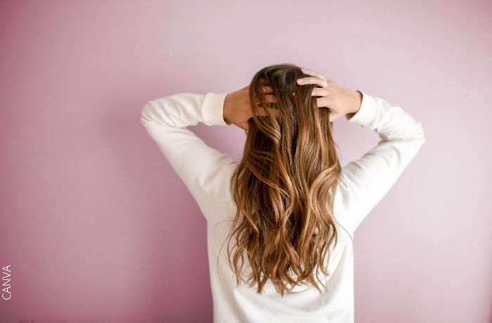 Foto de una mujer con las manos en su cabello