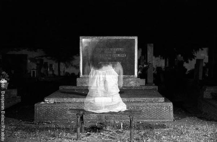 Ilustración de un fantasma frente a una tumba