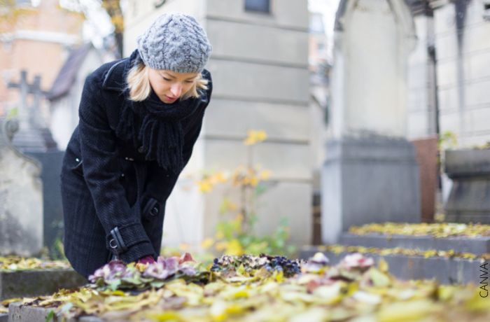 Foto de una mujer dejando flores en una tumba