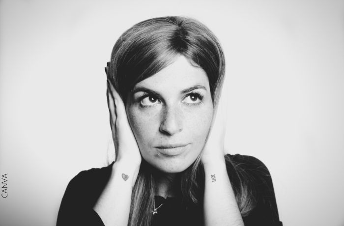 Foto de una mujer tapandose los oídos con las manos