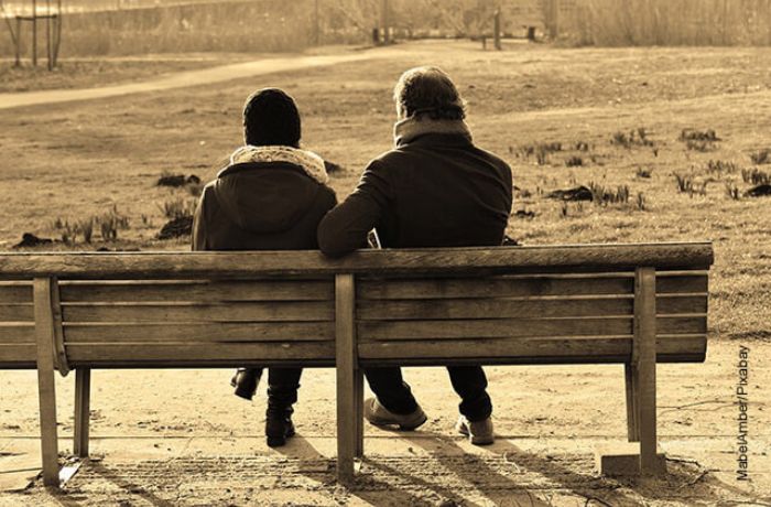 Foto sepia de un hombre y una mujer sentados en en un parque