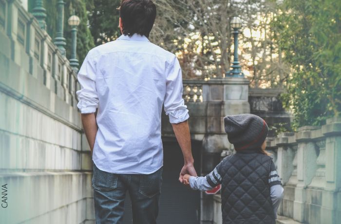 Foto de un padre caminando con su hijo de la mano