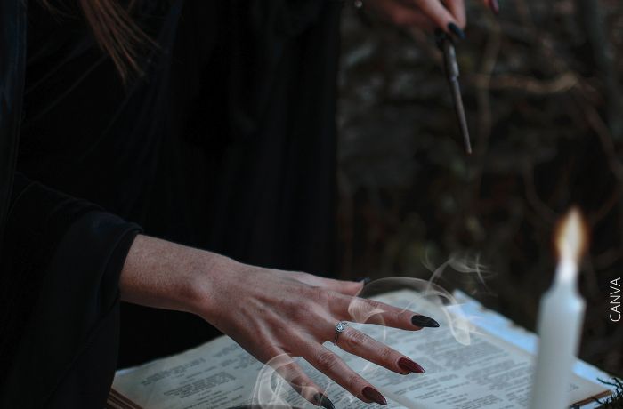 Foto de las manos de una mujer con una varita haciendo un hechizo