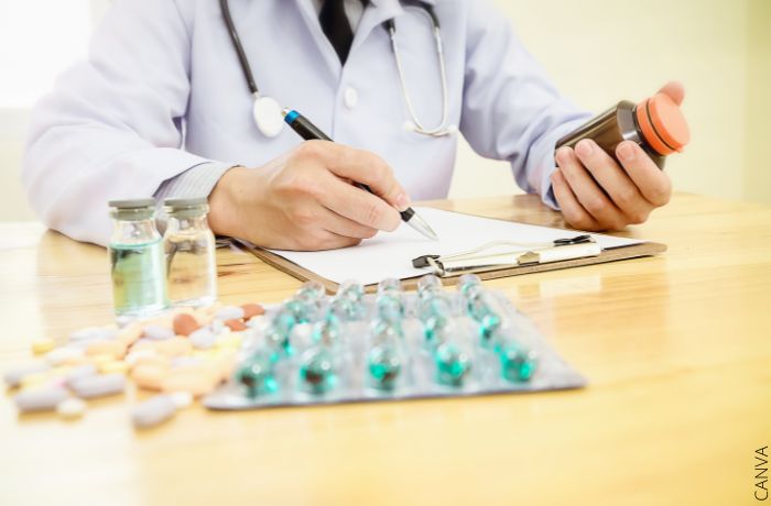 Foto de un doctor con medicamentos sobre el escritorio
