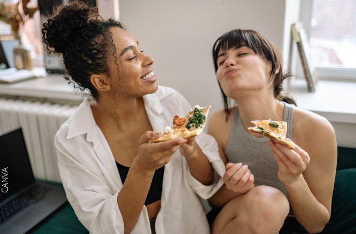 Foto de dos amigas comiendo pizza