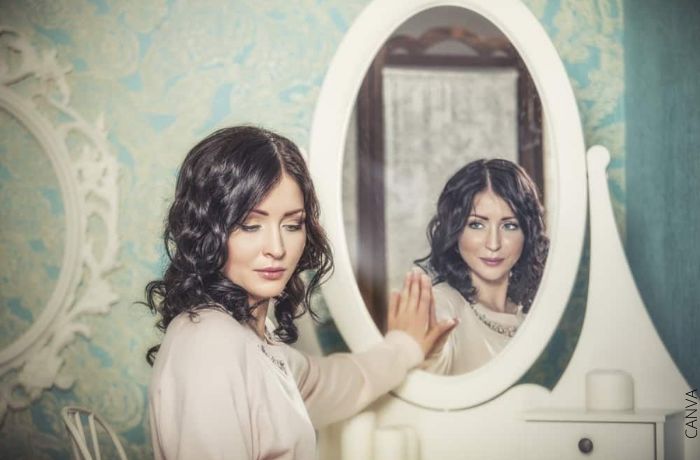 Ilustración de una mujer siendo vista por su reflejo en el espejo