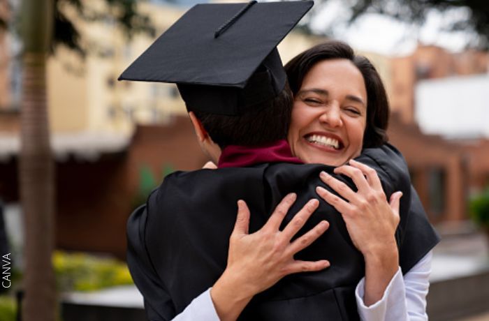 Foto de una mujer abranzando a su hijo graduado