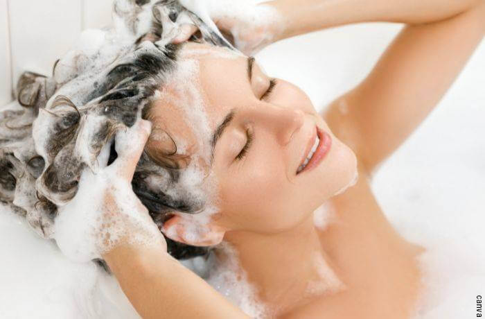 Foto de mujer lavándose el pelo