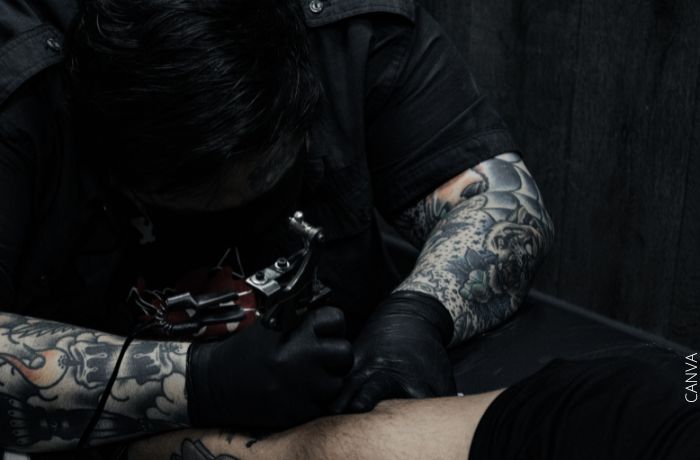 Foto de una persona tatuando el brazo de otra persona