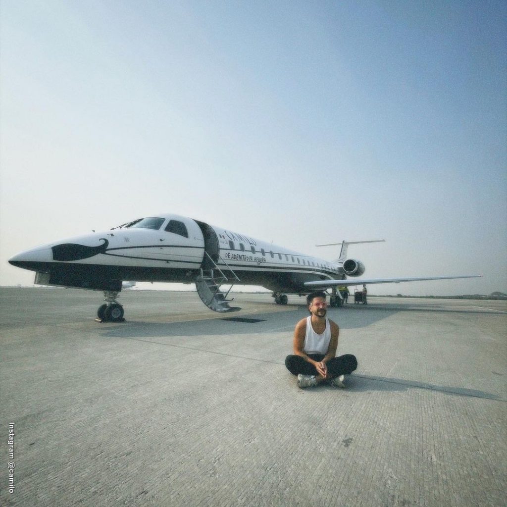 Foto de Camilo sentado frente a su avión personalizado