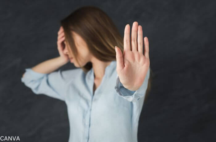 Foto de mujer con la palma de la mano al frente como diciento "basta"