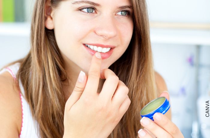 Foto de una mujer aplicándose vaselina en los labios