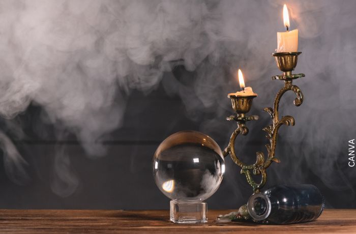 Foto de una bola de cristal con velas y humo