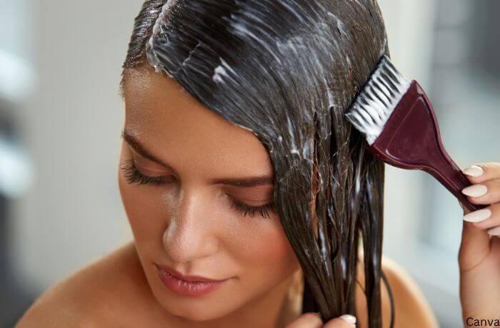 Foto de mujer aplicándose tintura en el pelo