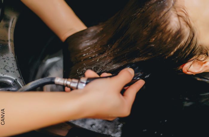 Foto de una persona lavando el cabello de una mujer