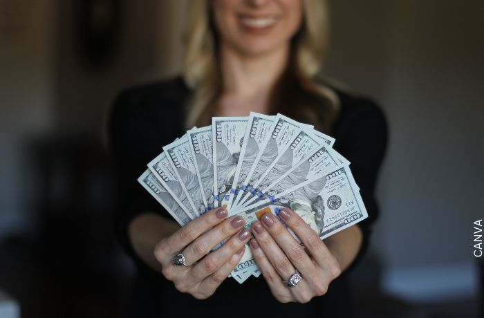 Foto de una mujer con billetes en mano