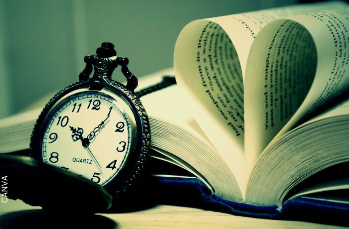 Foto de un reloj junto a un libro