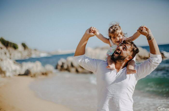Foto de un padre con un niño sobre sus hombros.