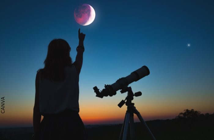 Foto de una mujer frente a un eclipse lunar