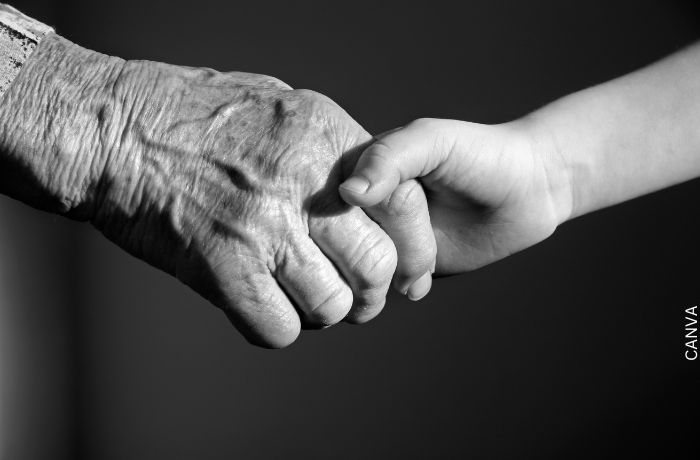 Foto de una mano de una anciana con la de una niña para ilustrar Mensajes de condolencias: los más adecuados para ocasión