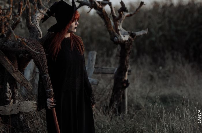 Foto de una mujer disfrazada de bruja con su escoba