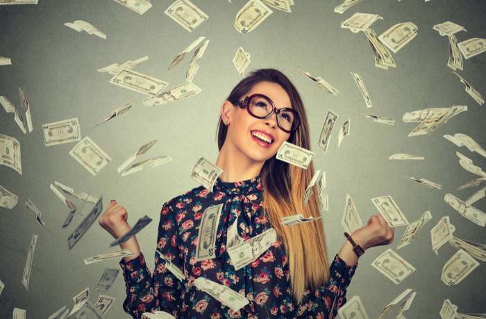 Foto de mujer feliz bajo lluvia de dinero