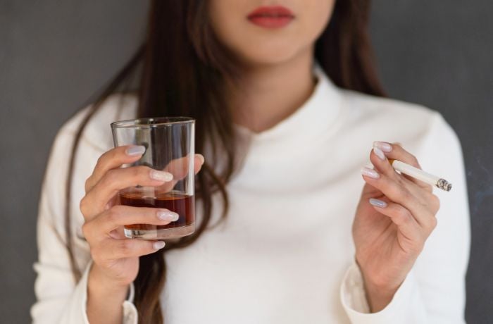 Foto de una mujer fumando y tomando