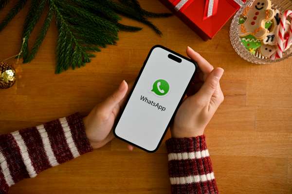 Teléfono con WhatsApp y algunas decoraciones navideñas de fondo