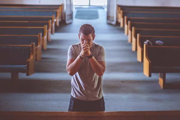 Hombre rezando en el altar de una iglesia