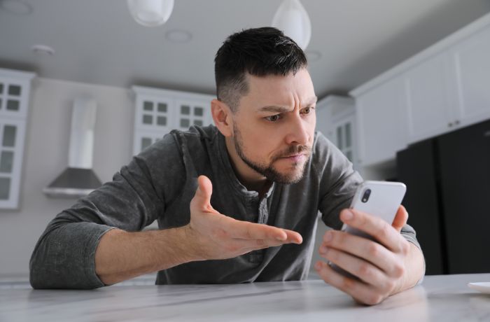 Foto de un hombre mirando su celular
