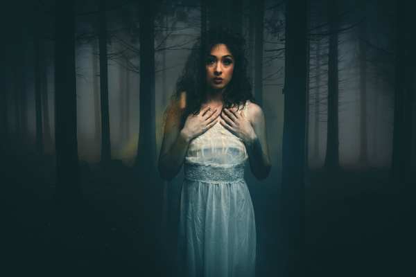 Foto de una mujer que sueña que está en el bosque y tiene un vestido blanco