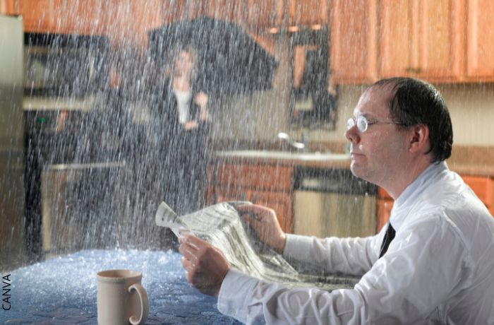 Foto de un hombre con lluvia dentro de casa