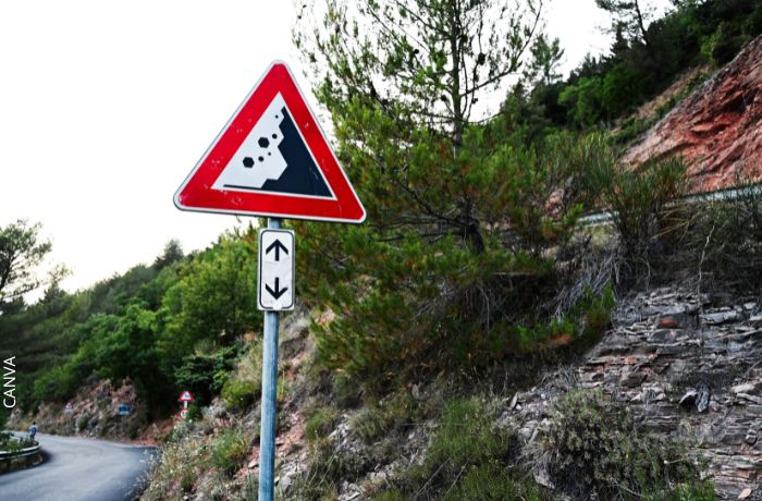 Foto de un cerro con un letrero de caída de piedras