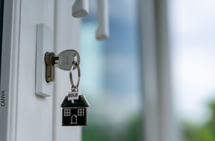 Foto de una llave puesta con un llavero en forma de casa