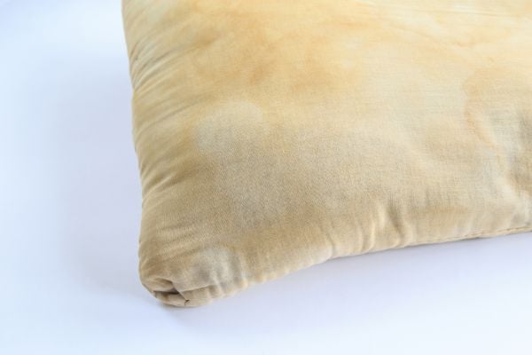 Almohada bastante deteriorada y con manchas en su superficie